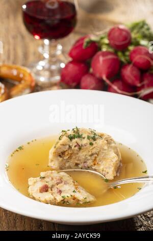 single bacon dumpling in soup on wood Stock Photo