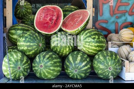 Watermelons on shelf. Cutted watermelon on street market Stock Photo