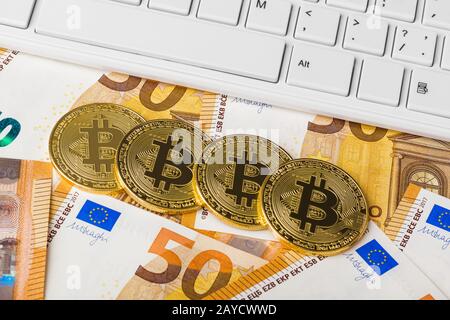 Computer and bitcoins on money - business background Stock Photo