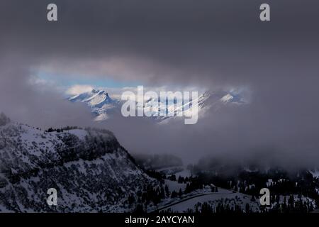Vista between clouds on sunlit mountains Stock Photo