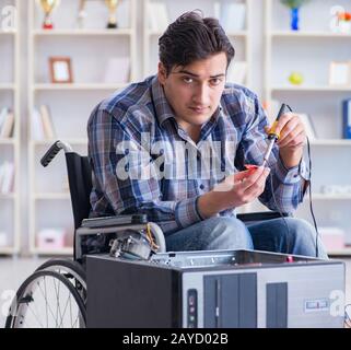 Computer repairman on wheelchair working Stock Photo