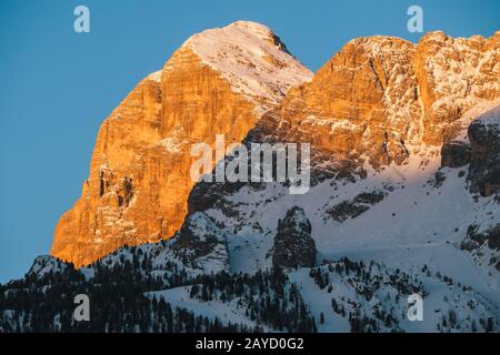 Tofana di Rozes or Tofana I Peak in Cortina d'Ampezzo in Winter at Dawn, Snow Covered at Sunrise with Early Morning Light with Ski Slopes Stock Photo