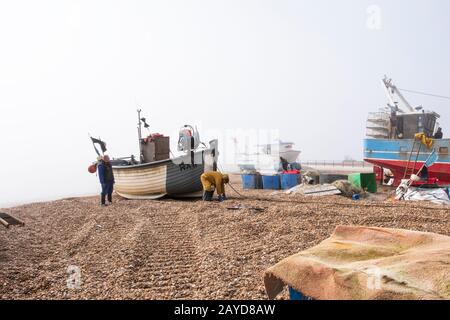 Hastings fishing boat being winched up beach, in the early morning mist, East Sussex, UK Stock Photo