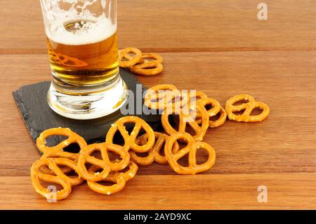 Pretzels and glass of lager on a wood background Stock Photo