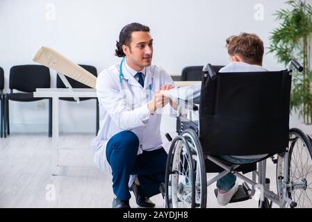 Young male doctor pediatrist and boy in wheel-chair Stock Photo