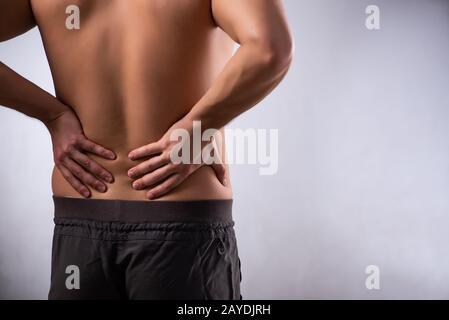 Man suffering from backbain on gray Stock Photo