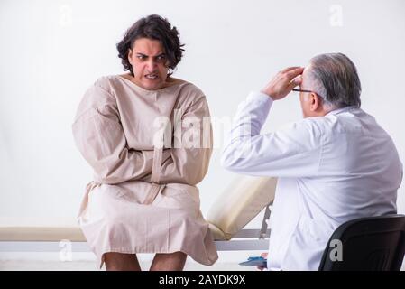 Aged male doctor psychiatrist examining young patient Stock Photo