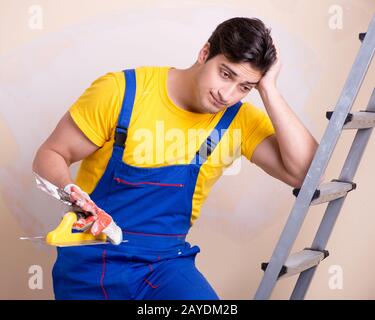 Young contractor employee applying plaster on wall Stock Photo