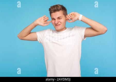 I don't hear! Portrait of man irritated by noisy sound covering his ears to avoid annoying talk, don't want to listen, being nervous avoiding conflict Stock Photo