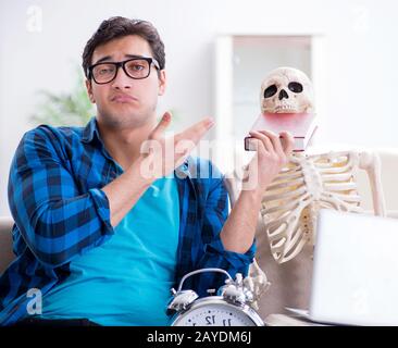 Student studying with skeleton preparing for exams Stock Photo