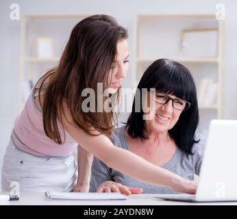 Daughter explaining to mom how to use computer Stock Photo