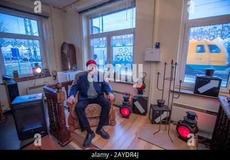 06 February 2020, Mecklenburg-Western Pomerania, Sülstorf: The Berlin taxi driver Michael Böhmke is sitting in his living room at the Sülstorf train station wearing a railway cap. A good two years ago Böhmke bought the station building on the railway line from Ludwigslust to Schwerin at an auction on Ebay. Gradually, he now wants to extend and renovate the building; he has already collected numerous collector's items relating to railway history. (to dpa ''This is my playground' - stations between decay and departure') Photo: Jens Büttner/dpa-Zentralbild/dpa Stock Photo