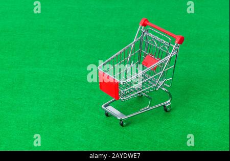 Toy shopping cart on green Stock Photo