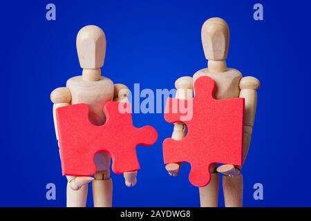 Wooden toy figures with puzzle on blue Stock Photo
