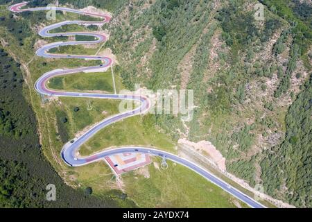 Aerial view of a winding mountain road through the Pyrenees forest with ...