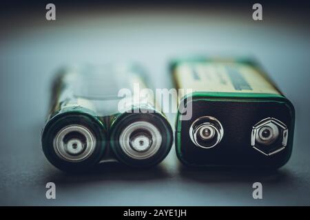 Two different types of batteries on the dark table close-up Stock Photo