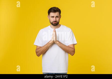 Calm and handsome. Portrait of handsome young man keeping hands clasped and looking thoughtful. Stock Photo