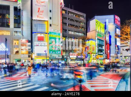 Shibuya, TOKYO, JAPAN - 29 December 2019: Famous Shibuya station and street crossing in Tokyo city at night with blurred people crowds and bright bill Stock Photo