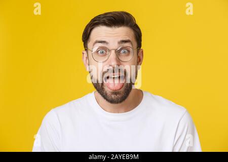 Young man looking at copyspace having a surprised or satisfied look isolated on yellow background. Stock Photo