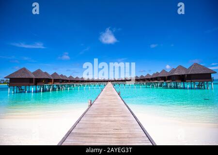 Water bungalows and wooden jetty on Maldives Stock Photo