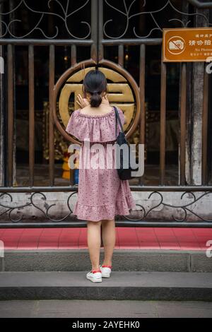Woman at the gates in Wenshu Monastery Stock Photo