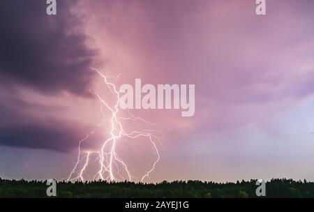Dramatic lightning bolt at night over rural area. Agriculture fields. Stock Photo