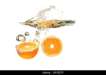 Two Orange fruits dropped into water splash on white background Stock Photo
