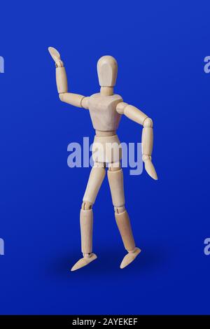 Dancing wooden toy figure on blue Stock Photo