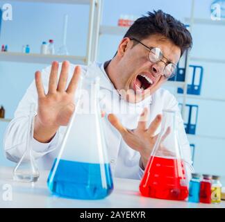 Funny mad chemist working in a laboratory Stock Photo
