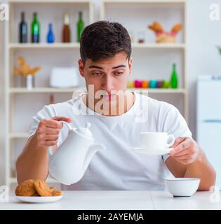 Man falling asleep during his breakfast after overtime work Stock Photo