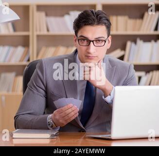 Businessman gambling playing cards at work Stock Photo