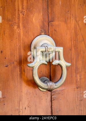 an antique brass Metallic door knocker on a wooden door Stock Photo