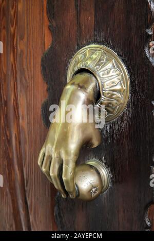 an antique brass Metallic door knocker on a wooden door Stock Photo