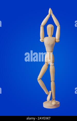 Dancing wooden toy figure on blue Stock Photo