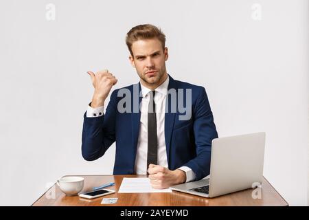 Get out of my office now. Serious-looking strict and bossy young man, scolding employee making bad report, pointing to exit and Stock Photo