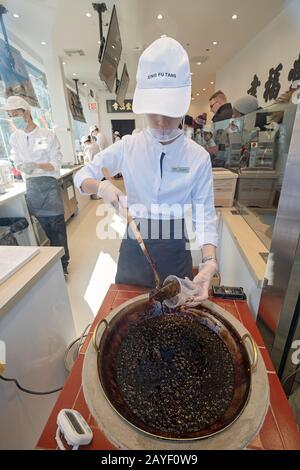 A young Asian American makes a boba milk drink in the window at Xing Fu Tang, a Taiwanese store on Main St. in Flushing, Queens, New York's Chinatown. Stock Photo