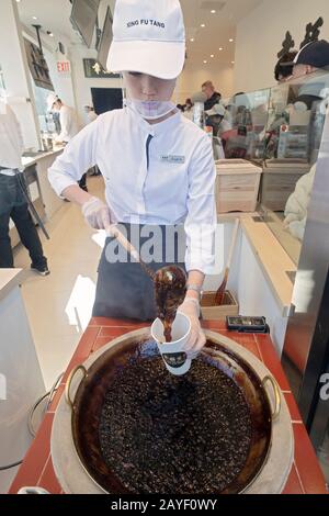 A young Asian American makes a boba milk drink in the window at Xing Fu Tang, a Taiwanese store on Main St. in Flushing, Queens, New York's Chinatown. Stock Photo