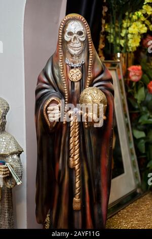 A Santa Muerte statue holding a globe displayed in a home temple in Jackson Heights, Queens, New York City. Stock Photo