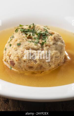single bacon dumpling in soup on wood Stock Photo