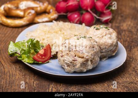 two bacon knodles with sauerkraut on wood Stock Photo