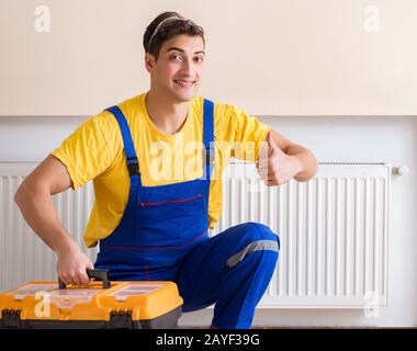 Young repairman contractor repairing heating panel Stock Photo