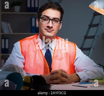 Construction architect working on drawings late at night Stock Photo