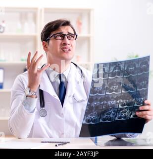 Young doctor looking at x-ray images in clinic Stock Photo