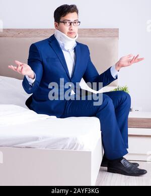 Businessman with neck injury working from home Stock Photo