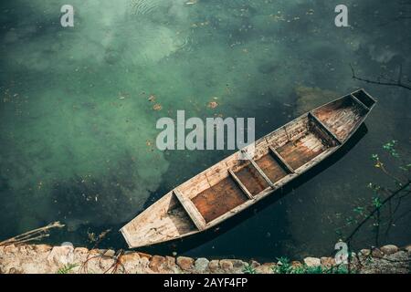 Small old wooden boat on the riverbank Stock Photo