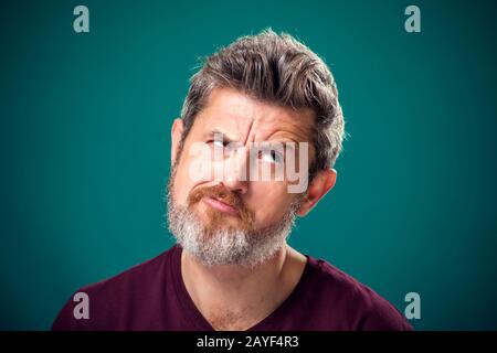 A portrait of pensive bearded man in red t-shirt. People and emotions concept Stock Photo