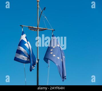 Greece flag and Europe flag against a blue sky Stock Photo
