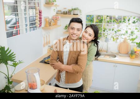 young asian couple cooking in kitchen Stock Photo