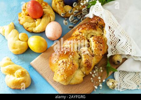 Traditional Italian Easter bread rings. Easter sweet bread with colored eggs on a blue stone concrete tabletop. Stock Photo