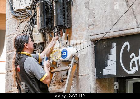 12 JULY 2018, BARCELONA, SPAIN: electrician engineer works with cables in electric network at city street Stock Photo